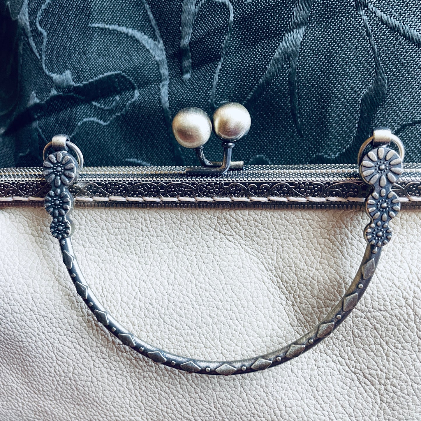 steamvoyage-pochette in pelle crema con chiusura clic clac bronzata a motivi floreali