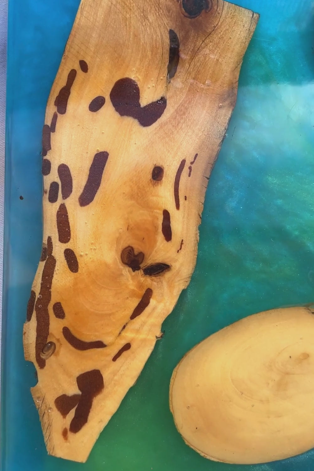 Sottopiatto quadrato in resina epoxy effetto mare con inserti in legno di ulivo