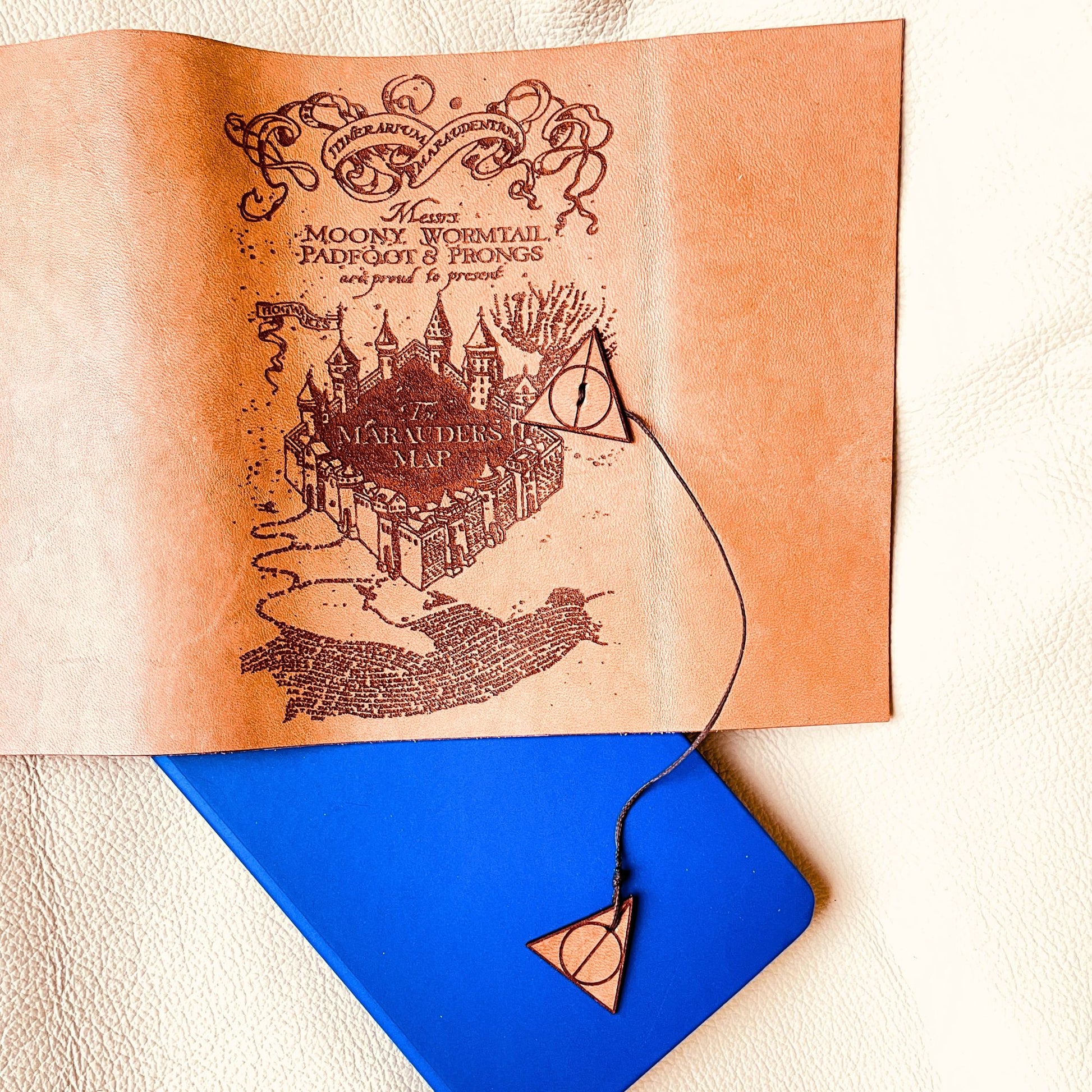 SteamVoyage - copertina per agenda A6 in cuoio con incisione a laser della Mappa del Malandrino e chiusura a cordino ornata da due simboli dei Doni della Morte