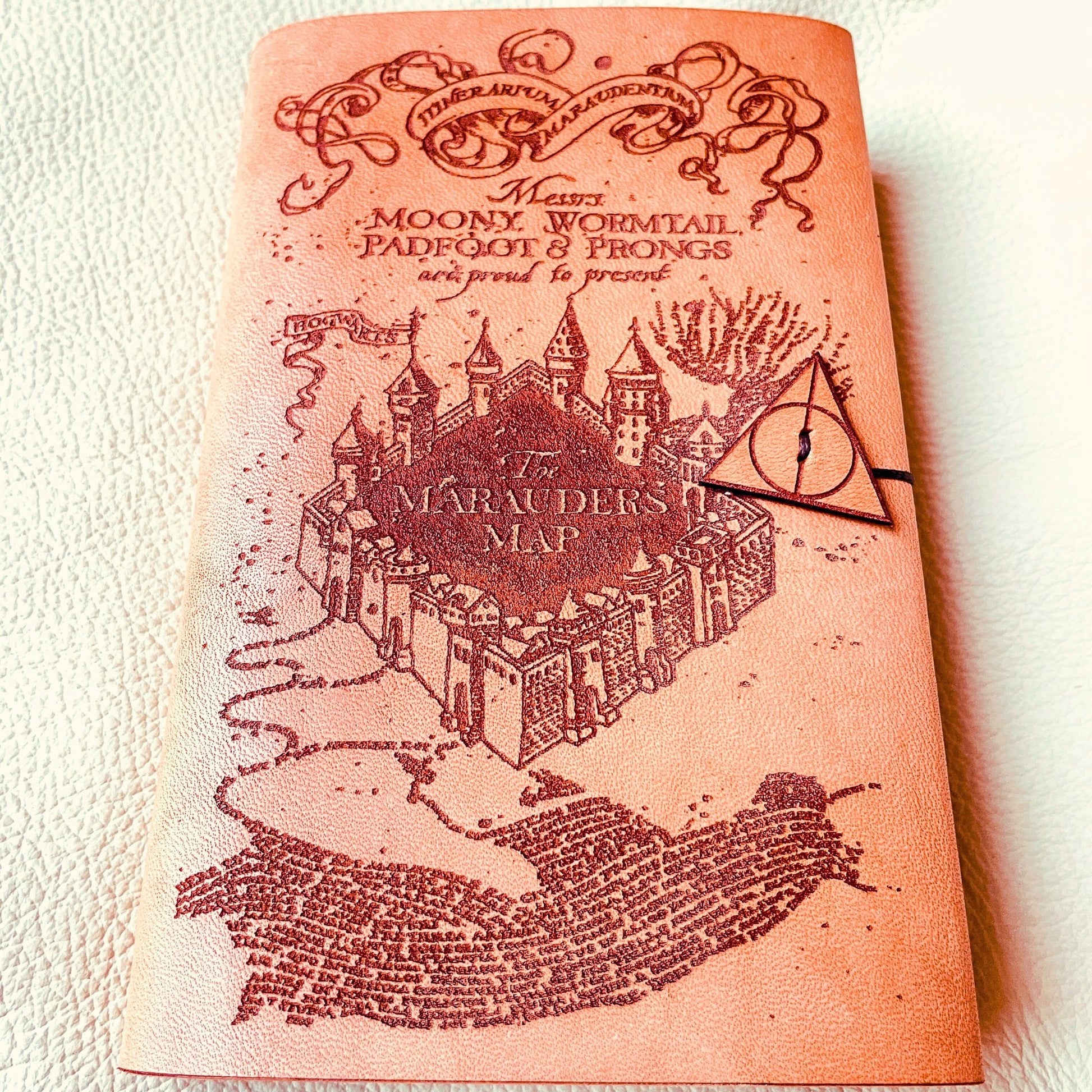 SteamVoyage - copertina per agenda A6 in cuoio con incisione a laser della Mappa del Malandrino e chiusura a cordino ornata da due simboli dei Doni della Morte
