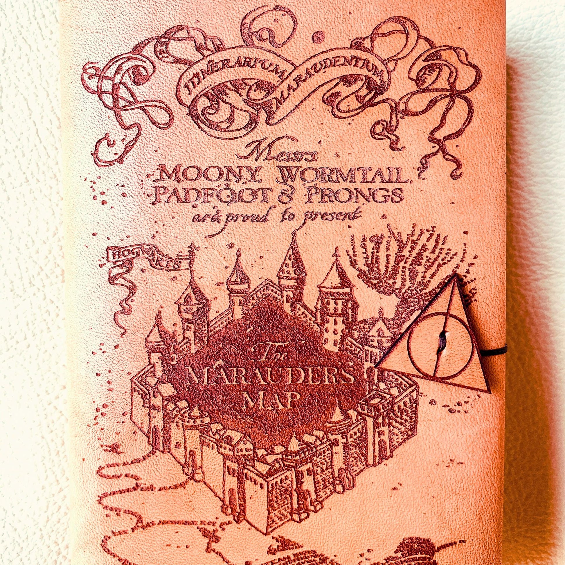 SteamVoyage - copertina per agenda A6 in cuoio con incisione a laser della Mappa del Malandrino e chiusura a cordino ornata da due simboli dei Doni della Morte