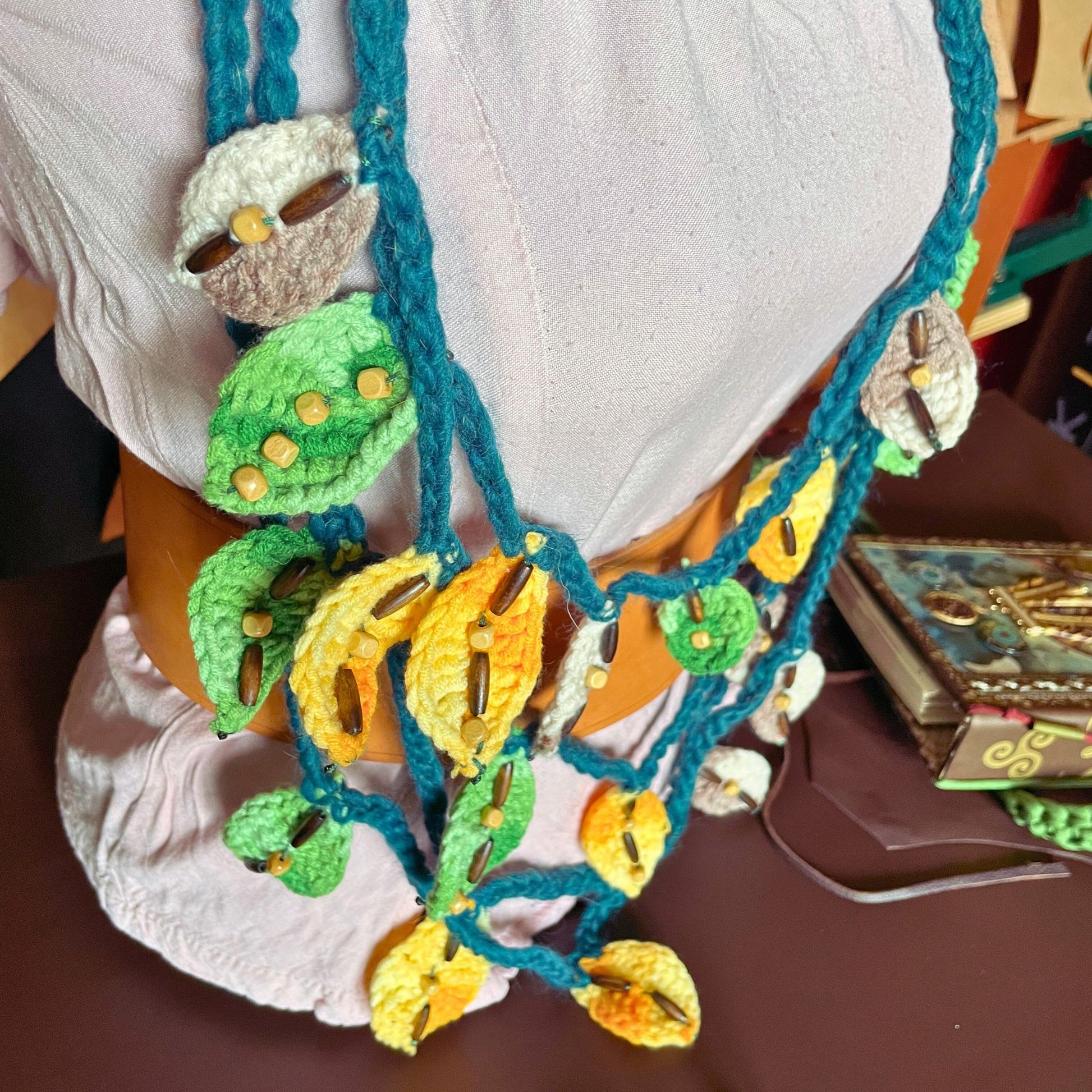 SteamVoyage - collana della sciamana in lana verde, arancione e marrone lavorata all'uncinetto con foglioline in lana e perline in legno per cosplay e LARP