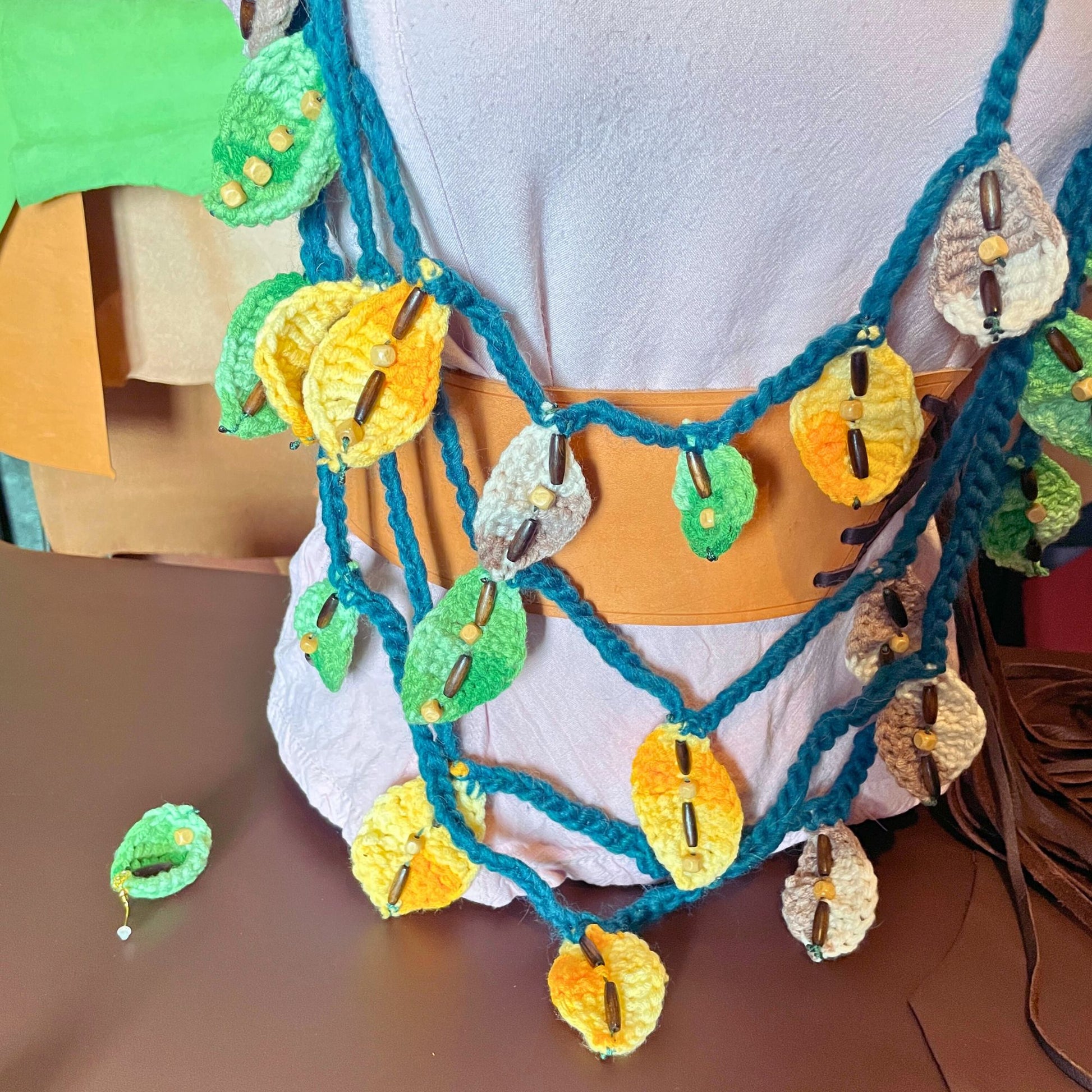 SteamVoyage - collana della sciamana in lana verde, arancione e marrone lavorata all'uncinetto con foglioline in lana e perline in legno per cosplay e LARP
