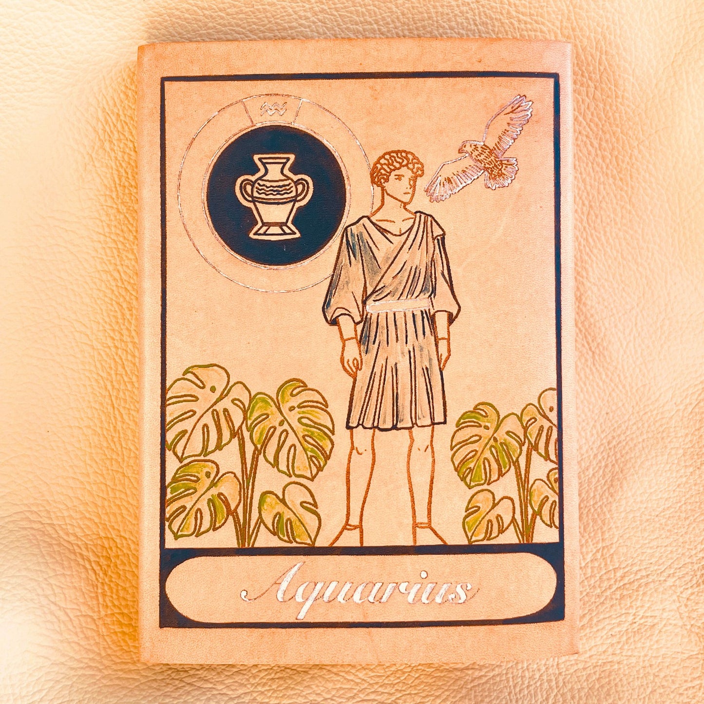 SteamVoyage - copertine per agende A6 in cuoio inciso al laser e dipinto a mano con immagini dei segni zodiacali ispirate ai miti greci - acquario