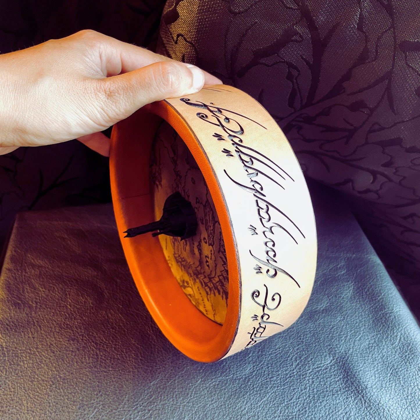 SteamVoyage - vassoio lancia dadi Torre di Sauron in cuoio e legno con incisione a laser della Mappa della Terra di Mezzo e Torre di Sauron in 3d; sul bordo del vassoio lancia dadi è presente l'incisione in elfico sull'Anello del Potere e il fondo nasconde una power bank in grado di illuminare la scritta dell'anello grazie ad un telecomando