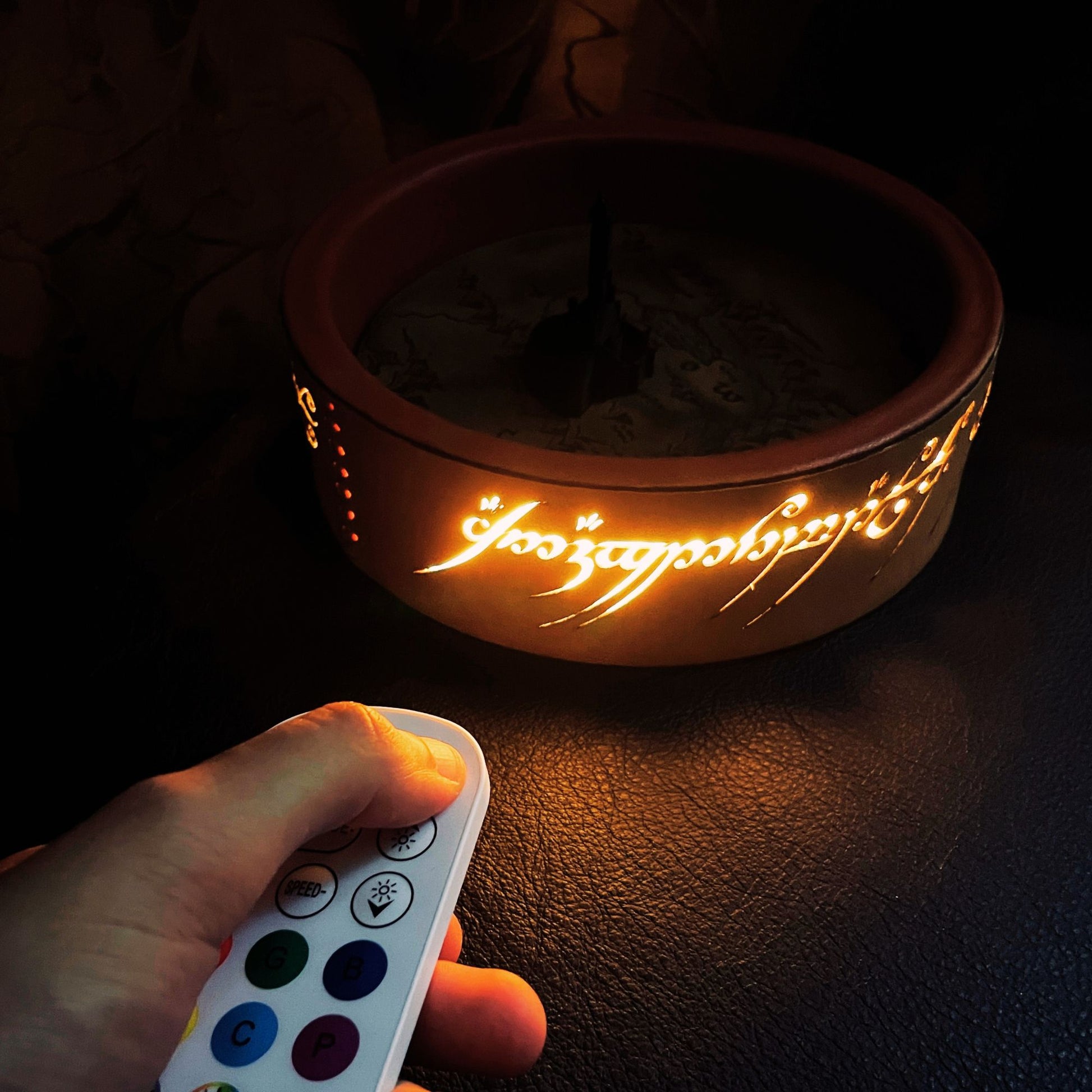 SteamVoyage - vassoio lancia dadi Torre di Sauron in cuoio e legno con incisione a laser della Mappa della Terra di Mezzo e Torre di Sauron in 3d; sul bordo del vassoio lancia dadi è presente l'incisione in elfico sull'Anello del Potere e il fondo nasconde una power bank in grado di illuminare la scritta dell'anello grazie ad un telecomando