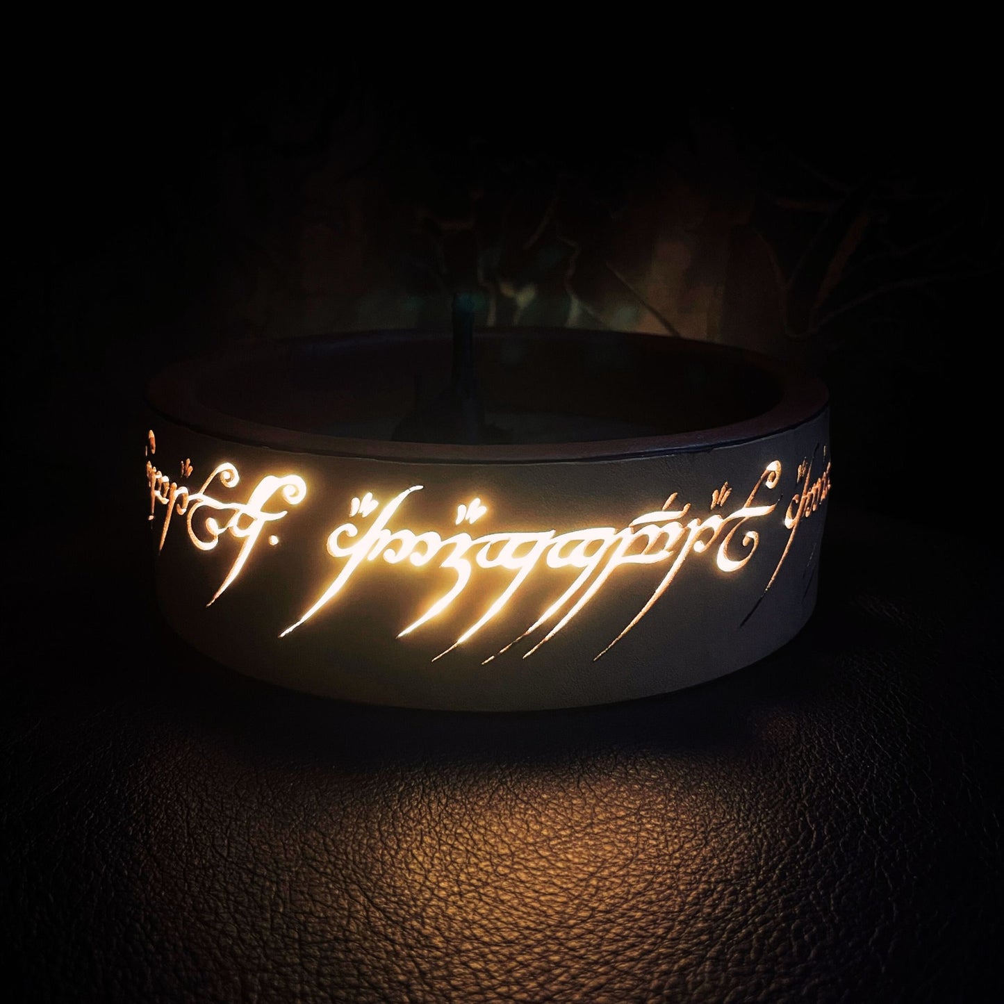 SteamVoyage - vassoio lancia dadi Torre di Sauron in cuoio e legno con incisione a laser della Mappa della Terra di Mezzo e Torre di Sauron in 3d; sul bordo del vassoio lancia dadi è presente l'incisione in elfico sull'Anello del Potere e il fondo nasconde una power bank in grado di illuminare la scritta dell'anello grazie ad un telecomando