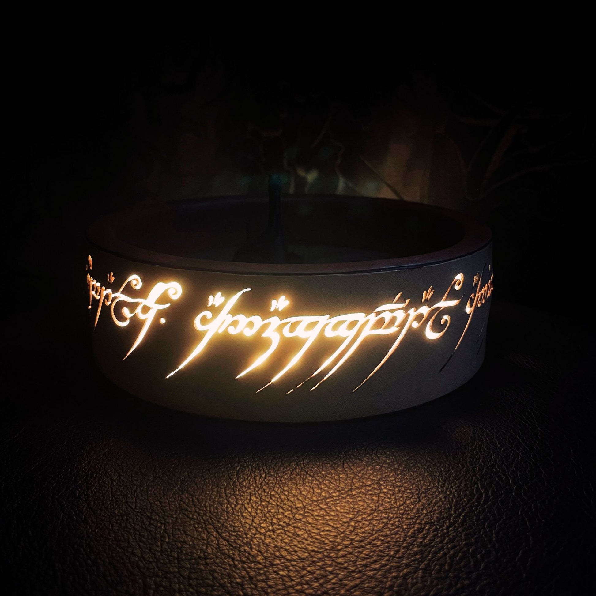 SteamVoyage - vassoio lancia dadi Torre di Sauron in cuoio e legno con incisione a laser della Mappa della Terra di Mezzo e Torre di Sauron in 3d; sul bordo del vassoio lancia dadi è presente l'incisione in elfico sull'Anello del Potere e il fondo nasconde una power bank in grado di illuminare la scritta dell'anello grazie ad un telecomando
