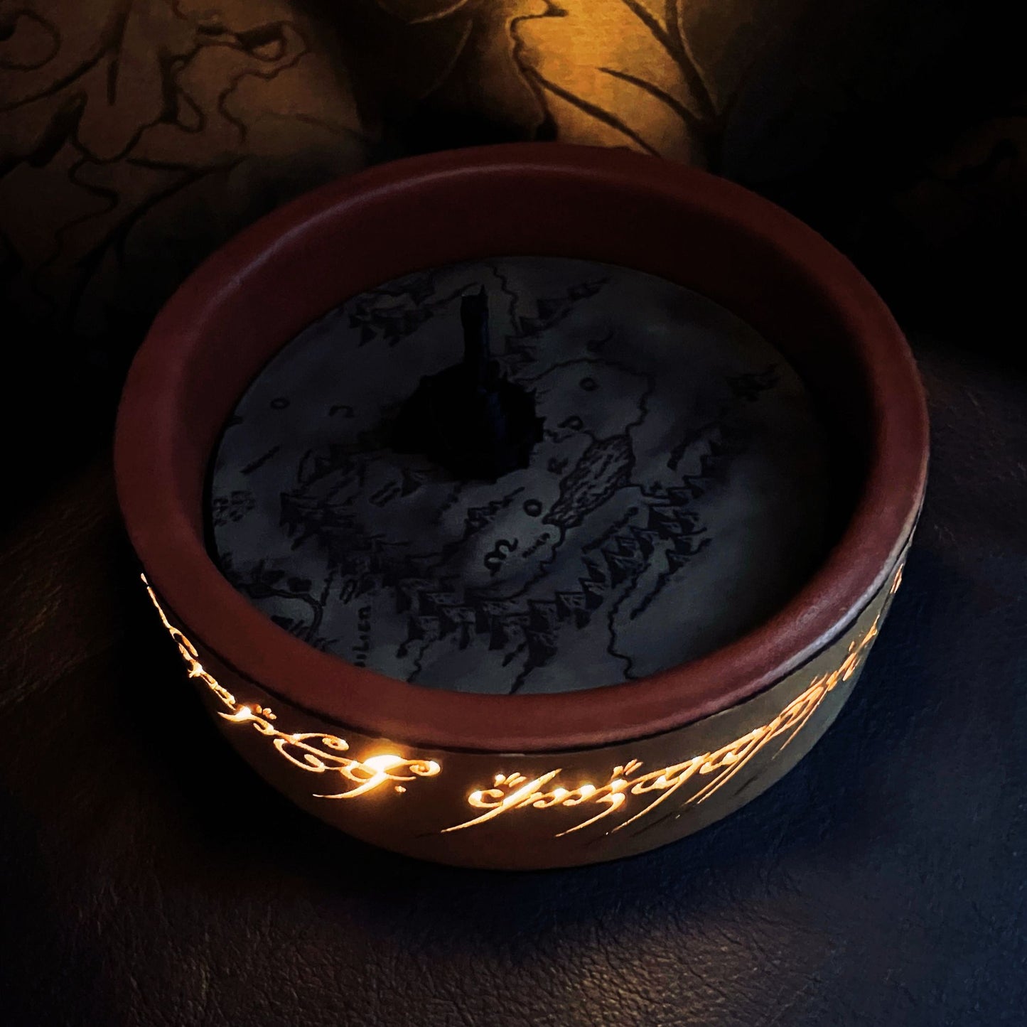 SteamVoyage - vassoio lancia dadi Torre di Sauron in cuoio e legno con incisione a laser della Mappa della Terra di Mezzo e Torre di Sauron in 3d; sul bordo del vassoio lancia dadi è presente l'incisione in elfico sull'Anello del Potere e il fondo nasconde una power bank in grado di illuminare la scritta dell'anello grazie ad un telecomando
