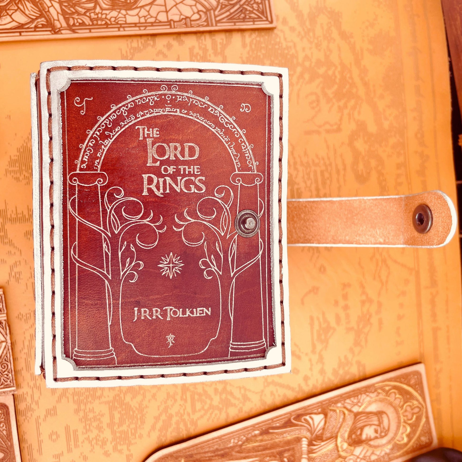 SteamVoyage-portamazzo Magic luminescente Porte di Durin-parte frontale con titolo del libro e incisione delle Porte di Durin in argento su cuoio rosso