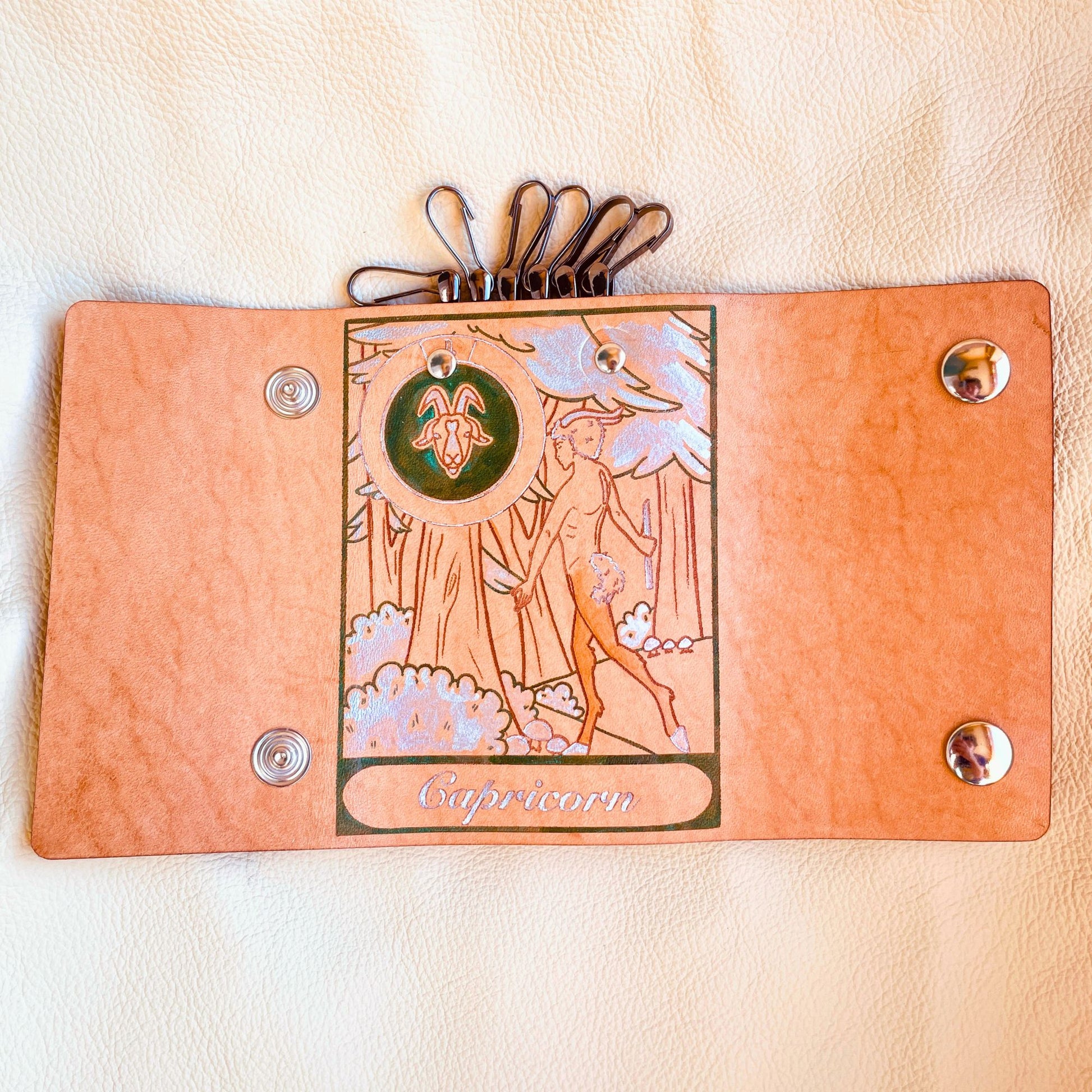 SteamVoyage - portachiavi in cuoio inciso al laser e dipinto a mano con immagini ispirate ai segni zodiacali e ai relativi miti greci e romani - capricorno verde aperto