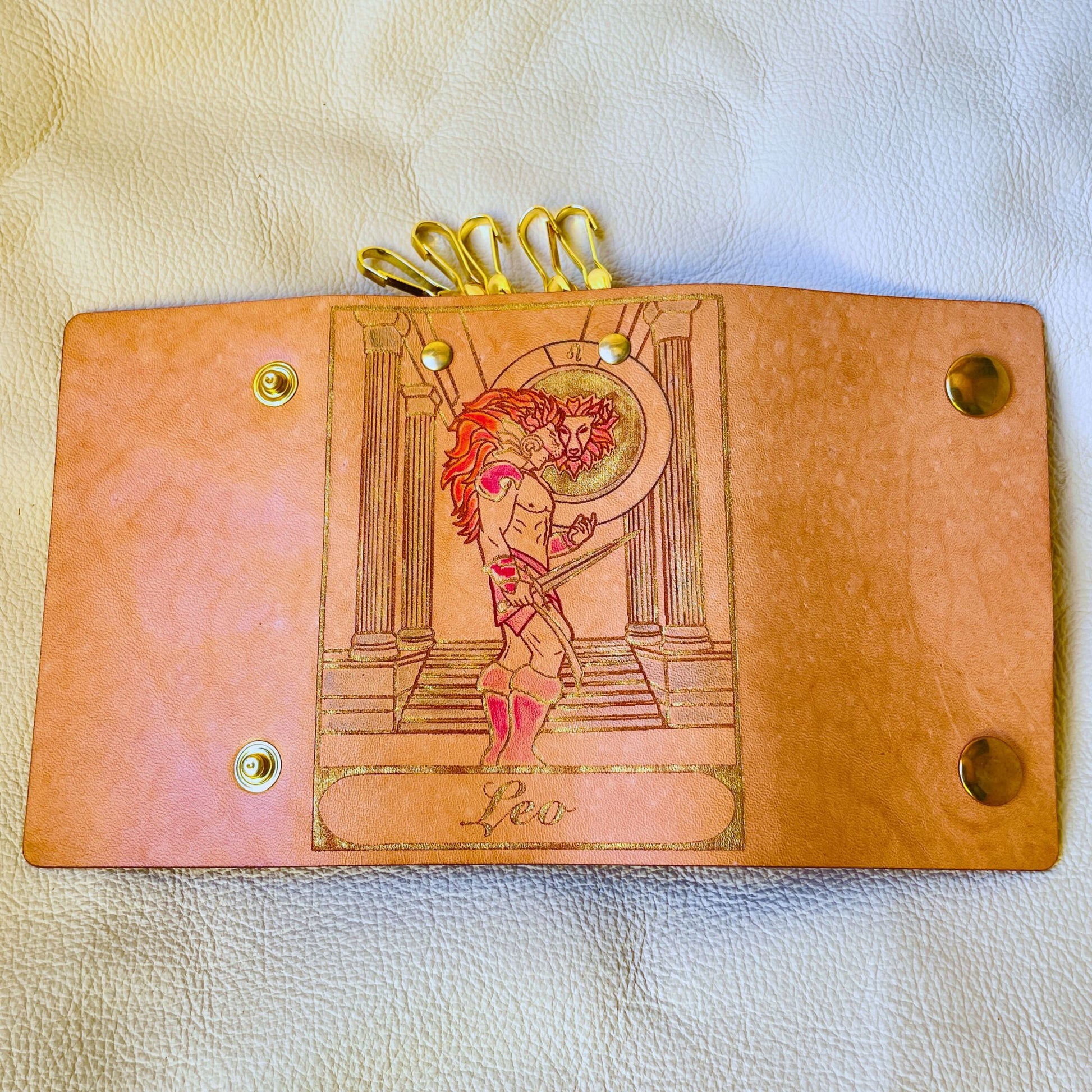 SteamVoyage - portachiavi in cuoio inciso al laser e dipinto a mano con immagini ispirate ai segni zodiacali e ai relativi miti greci e romani - leone oro aperto