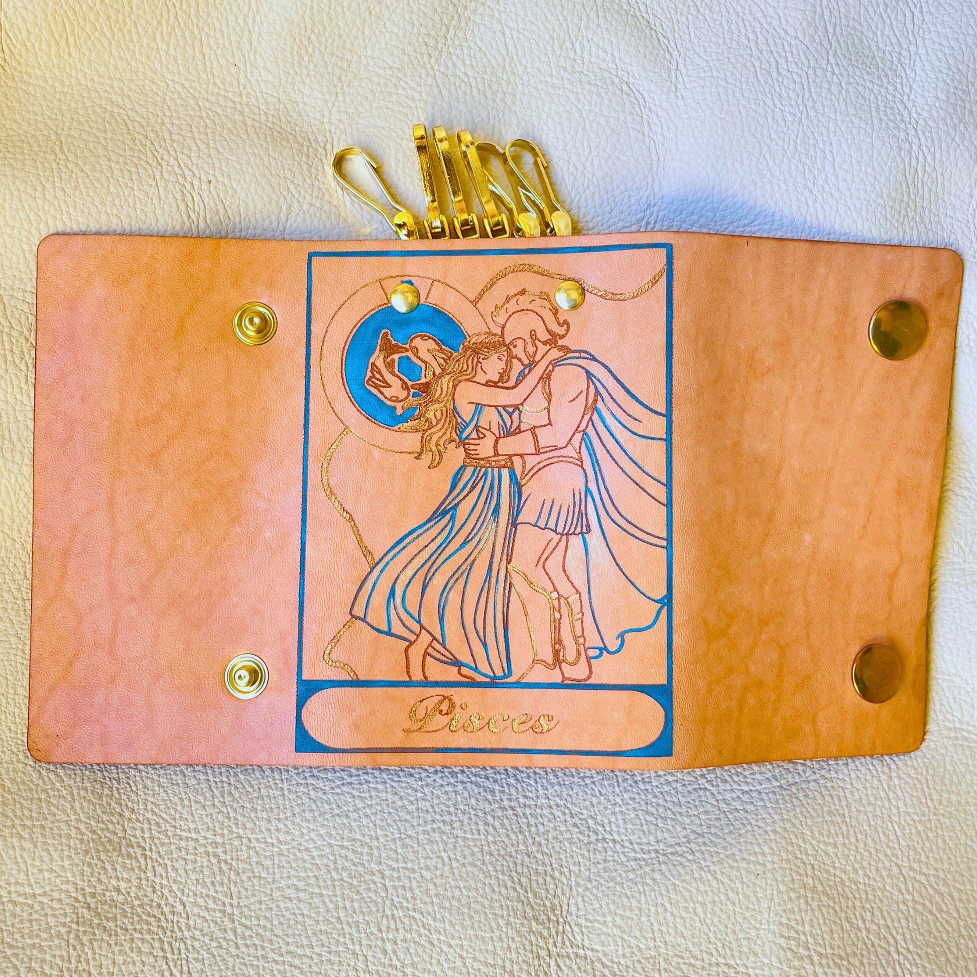 SteamVoyage - portachiavi in cuoio inciso al laser e dipinto a mano con immagini ispirate ai segni zodiacali e ai relativi miti greci e romani - pesci azzurro aperto