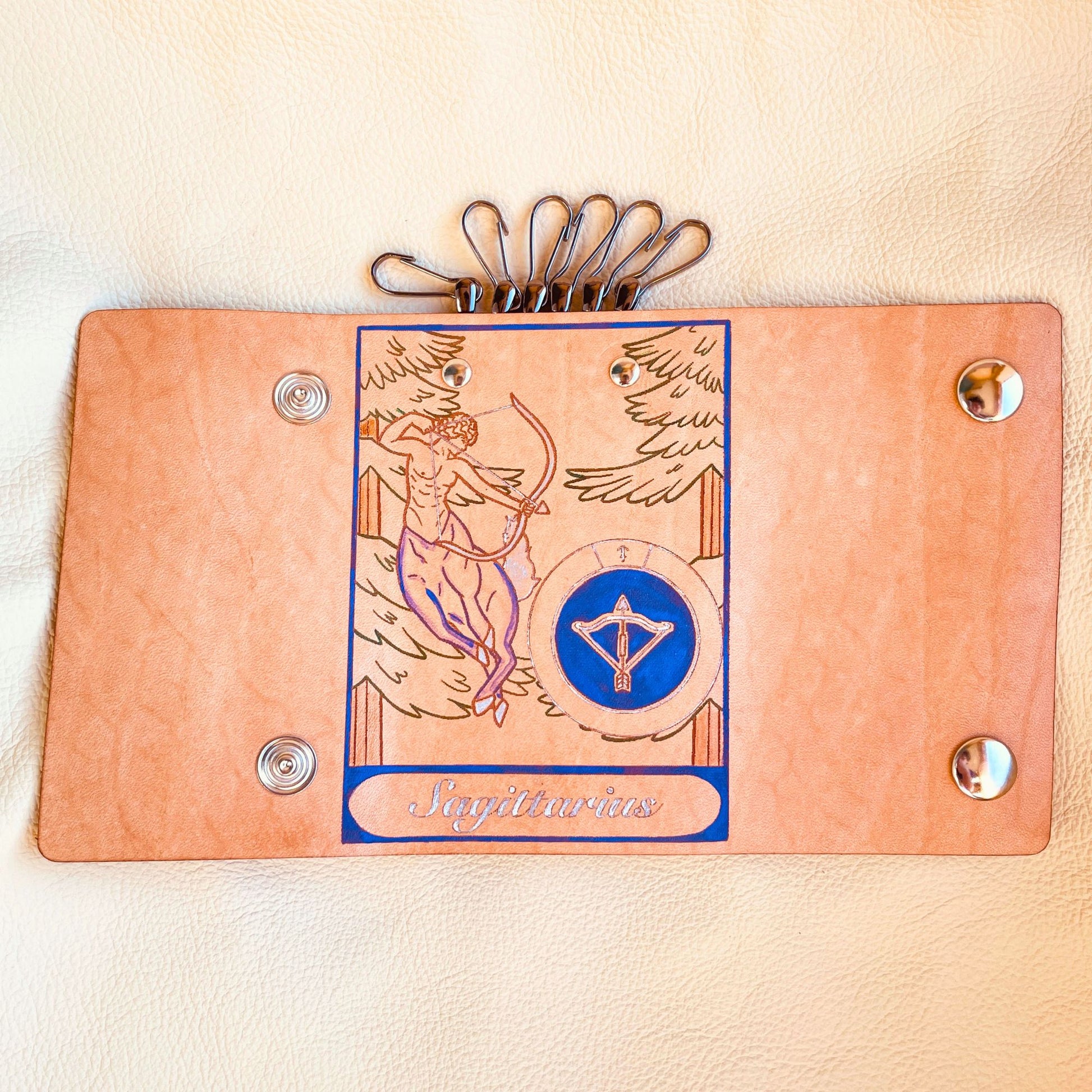 SteamVoyage - portachiavi in cuoio inciso al laser e dipinto a mano con immagini ispirate ai segni zodiacali e ai relativi miti greci e romani - sagittario viola aperto