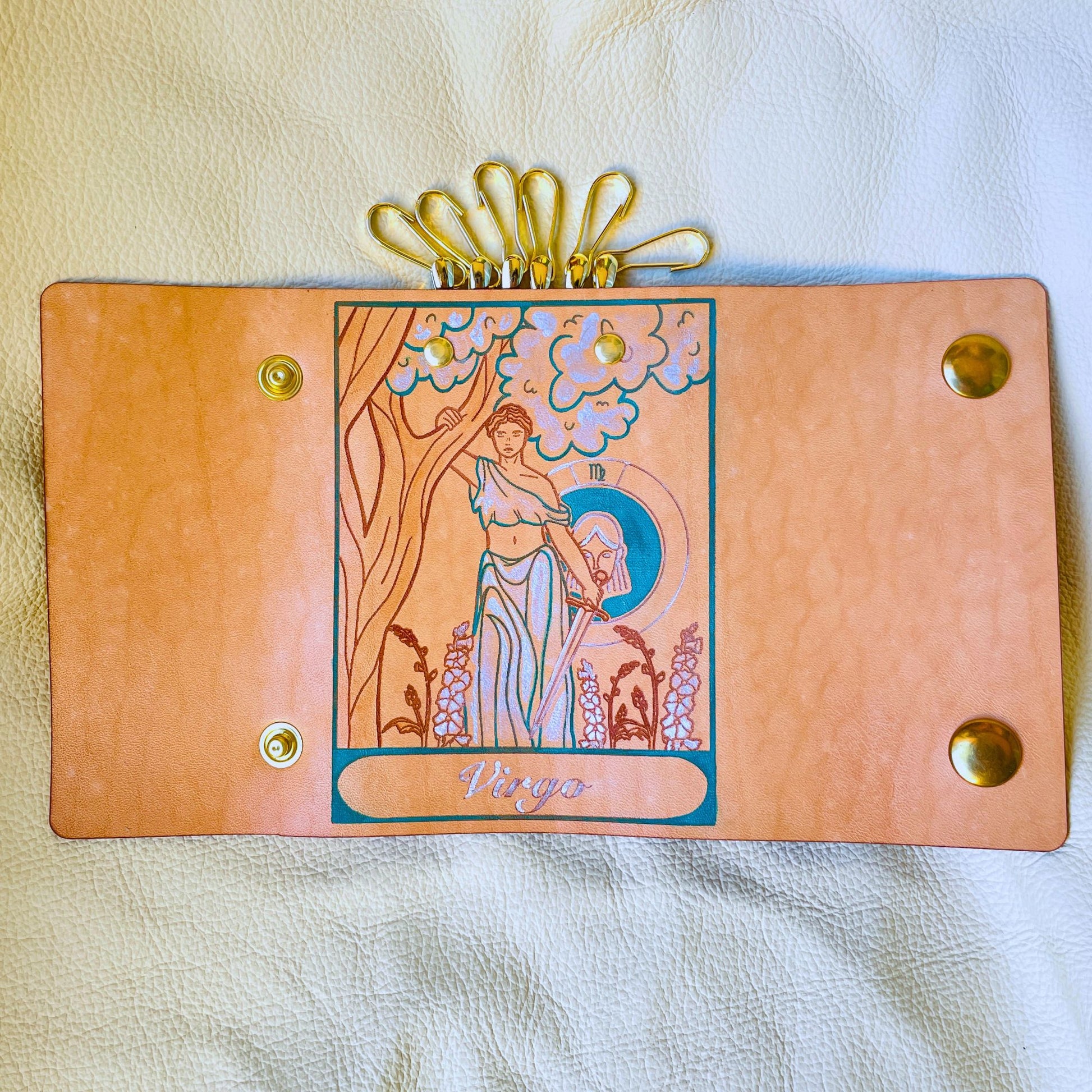 SteamVoyage - portachiavi in cuoio inciso al laser e dipinto a mano con immagini ispirate ai segni zodiacali e ai relativi miti greci e romani - vergine azzurro aperto