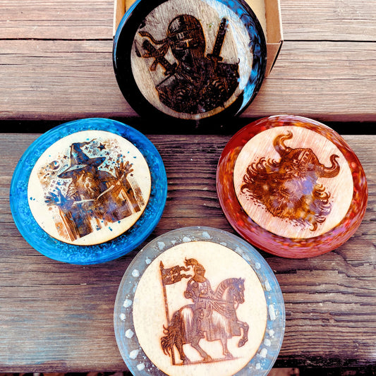 Quattro Sottobicchieri in resina nera, azzurra, rossa e bianca con inserto in legno con incisione del mago, dell'assassino, del guerriero e del paladino di dungeons and dragons